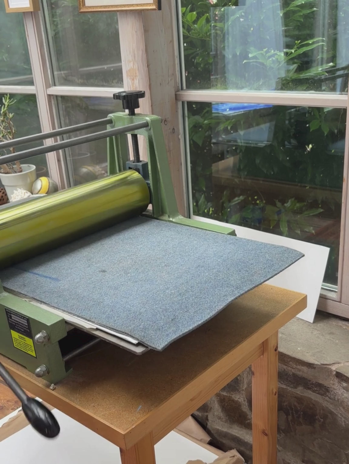 Printprozess eines Linoldruck-Posters auf dem Käse, Weintrauben und Wein in blau zu sehen sind